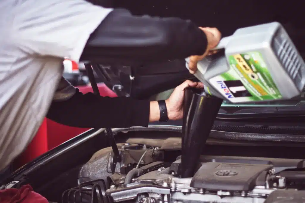 Mechanic adding oil to a car